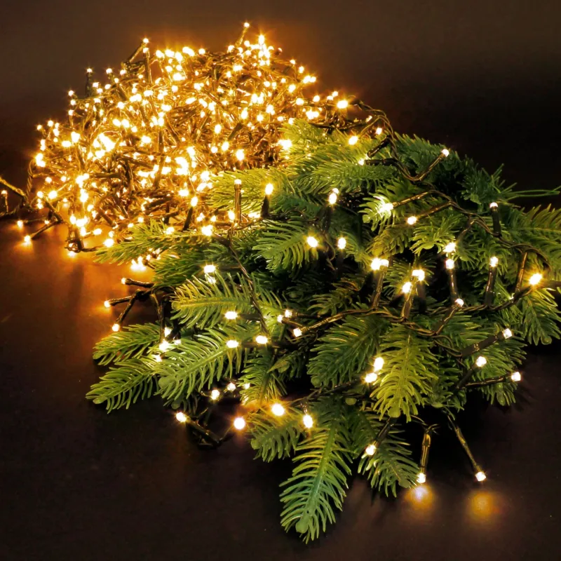 Lichterkette auf Tannenzweigen, auf schwarzem Hintergrund.