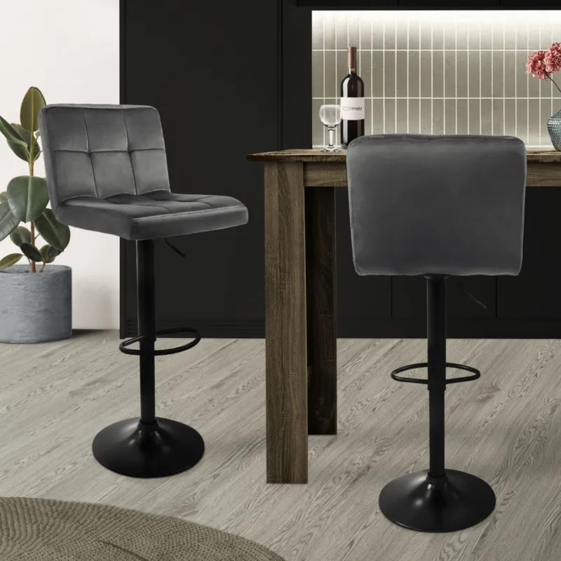 Zwei graue Barhocker an einem Tisch in einer modernen Küche.